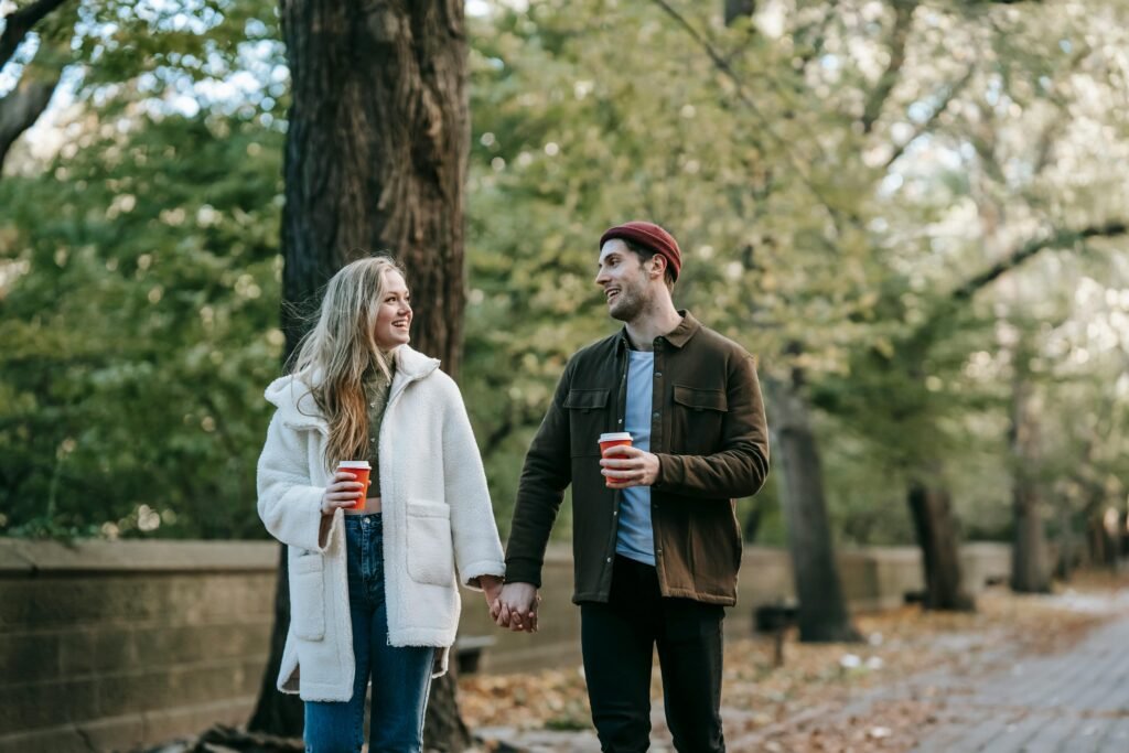 Photo by Katerina Holmes: https://www.pexels.com/photo/positive-young-couple-holding-hands-and-drinking-coffee-while-walking-in-park-5910806/