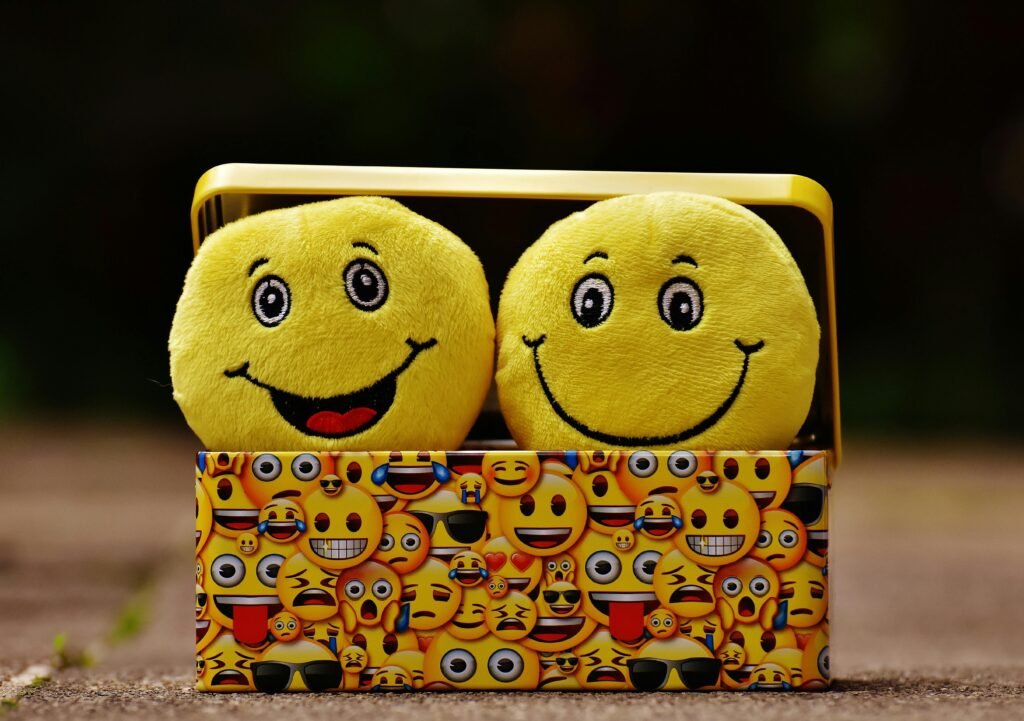 pexels-photo-207983-207983 Two yellow smiley plush toys in an emoji-themed box, expressing fun and happiness.