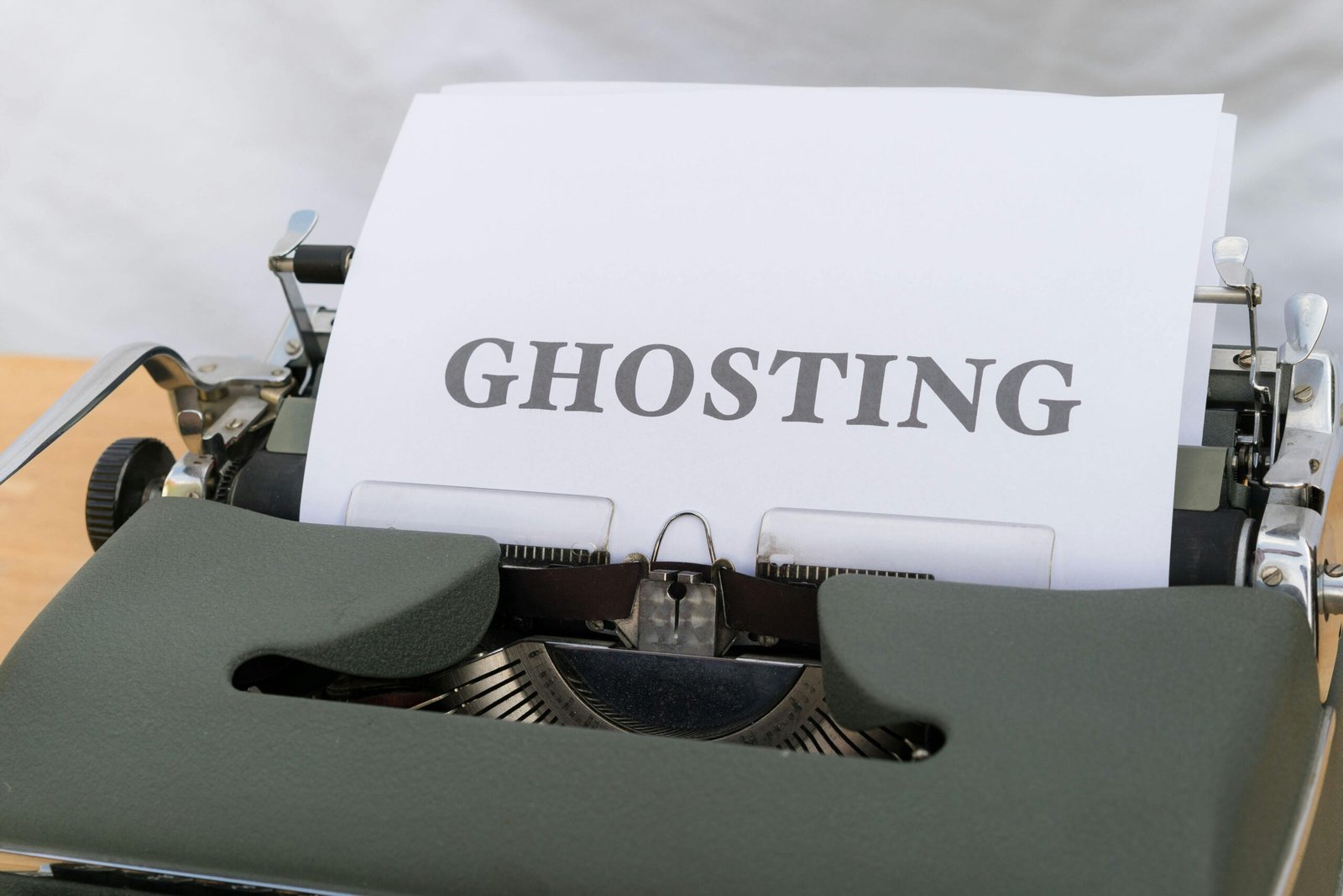 Close-up of a typewriter typing 'Ghosting' on an empty sheet indoors.